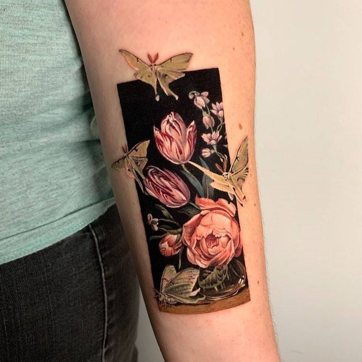 a woman with a tattoo on her arm has flowers in a vase and butterflies around it