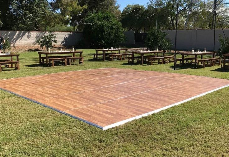 an outdoor tennis court surrounded by tables and benches