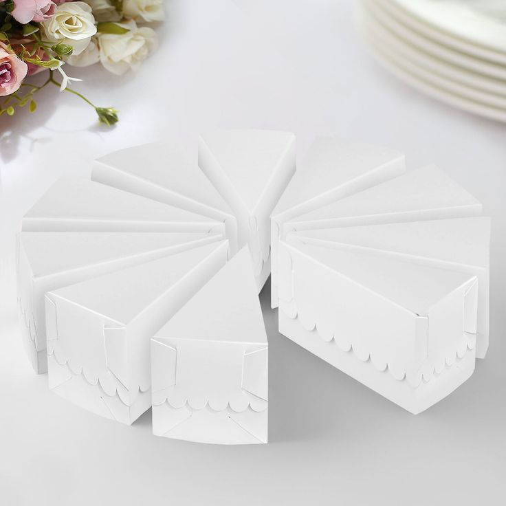 several pieces of white paper sitting on top of a table next to plates and flowers