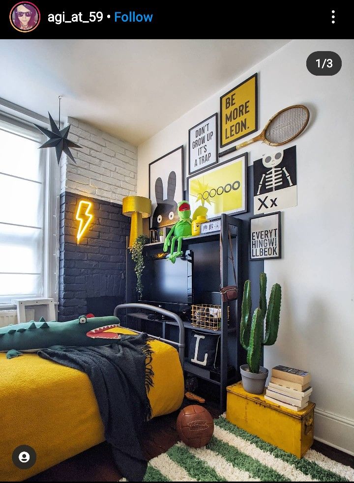 a bedroom decorated in yellow and black with pictures on the wall