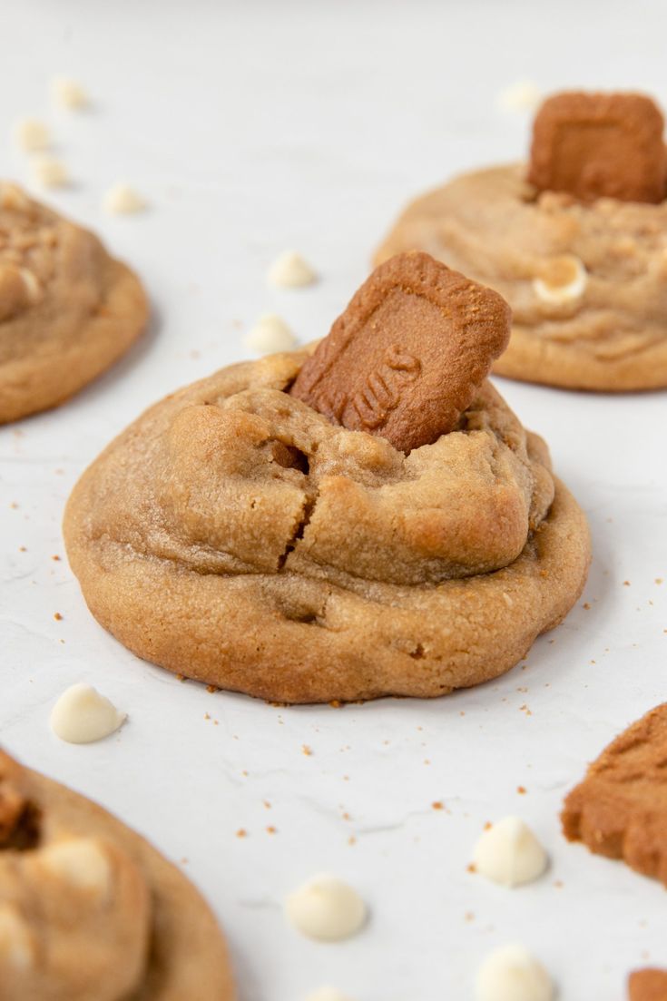 several cookies with white chocolate chips on top and one has a cookie in the middle