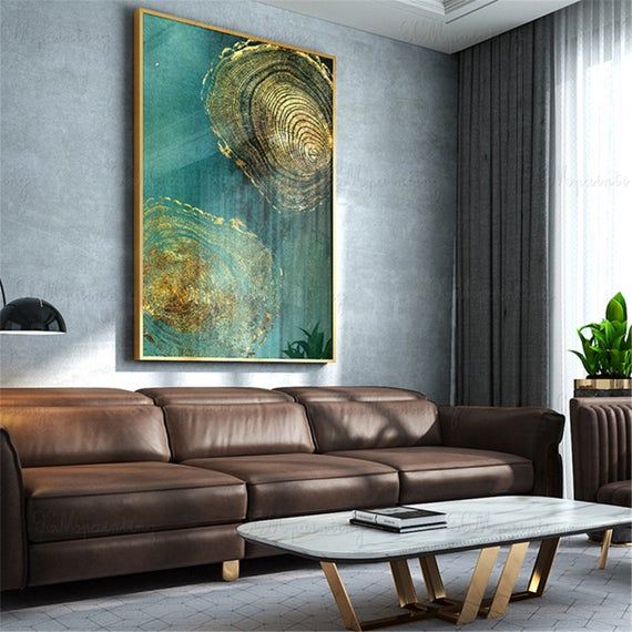 a living room with a couch, coffee table and large painting on the wall above it