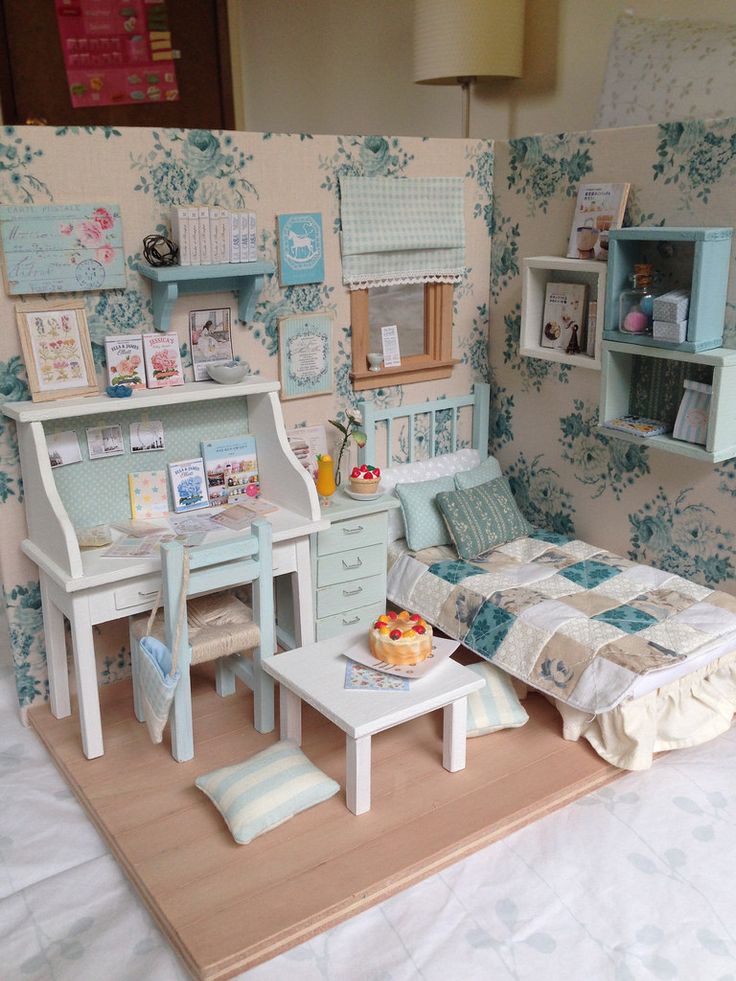 a dollhouse bedroom with a bed, desk and dresser in the middle of it