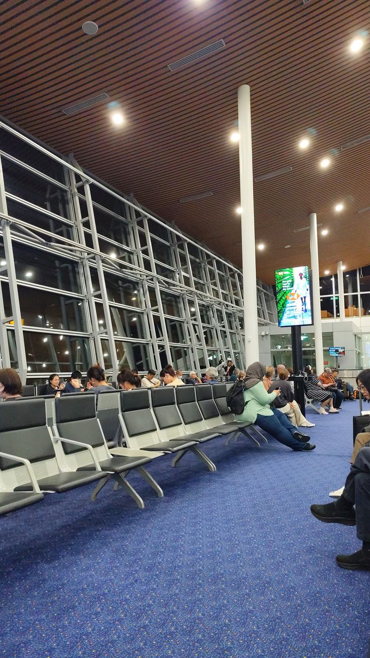 people are sitting in the waiting area at an airport