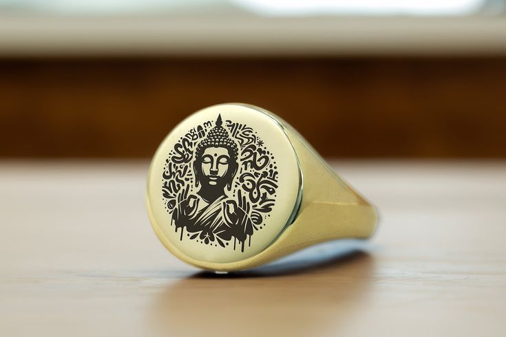 a gold ring with an image of jesus on the front and sides, sitting on top of a wooden table