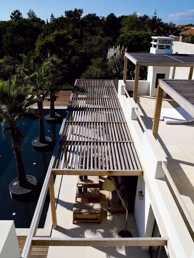 an aerial view of a house with trees and water