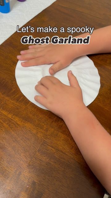 a child's hand on a paper plate with the words let's make a spooky ghost garland