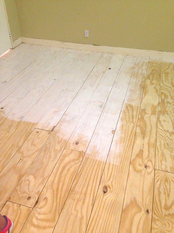 a person is standing on the floor in front of a wall with wood planks