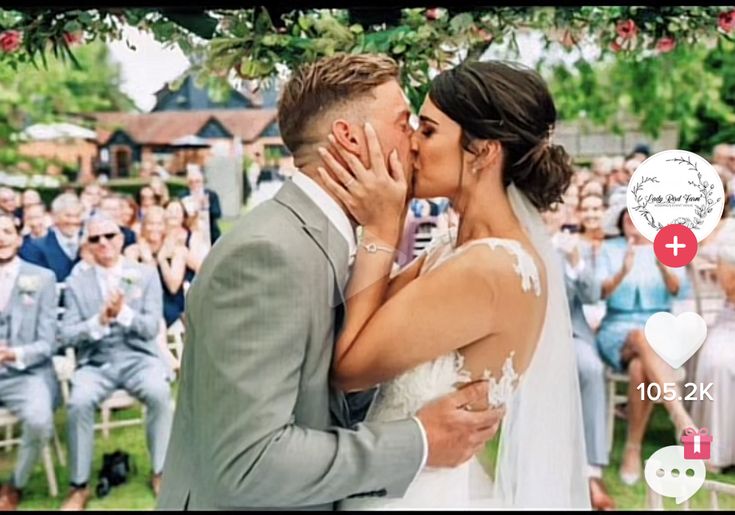 a bride and groom kissing in front of an audience