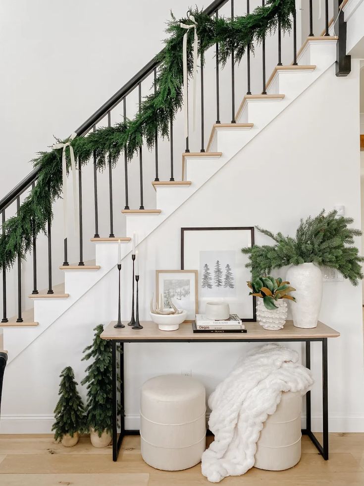 a staircase decorated for christmas with greenery