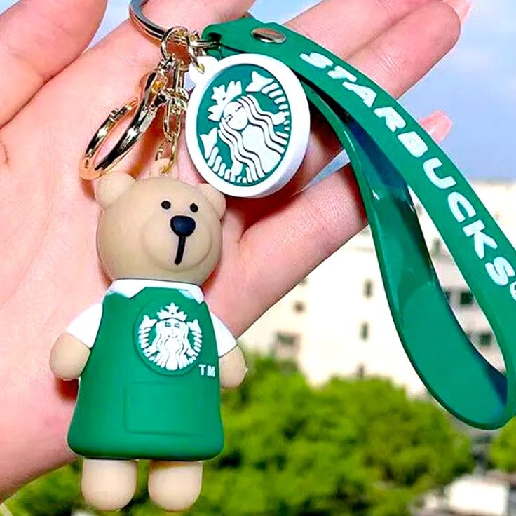 a starbucks keychain with a small teddy bear attached to it's neck