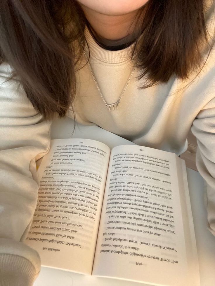 a woman is reading a book while sitting down