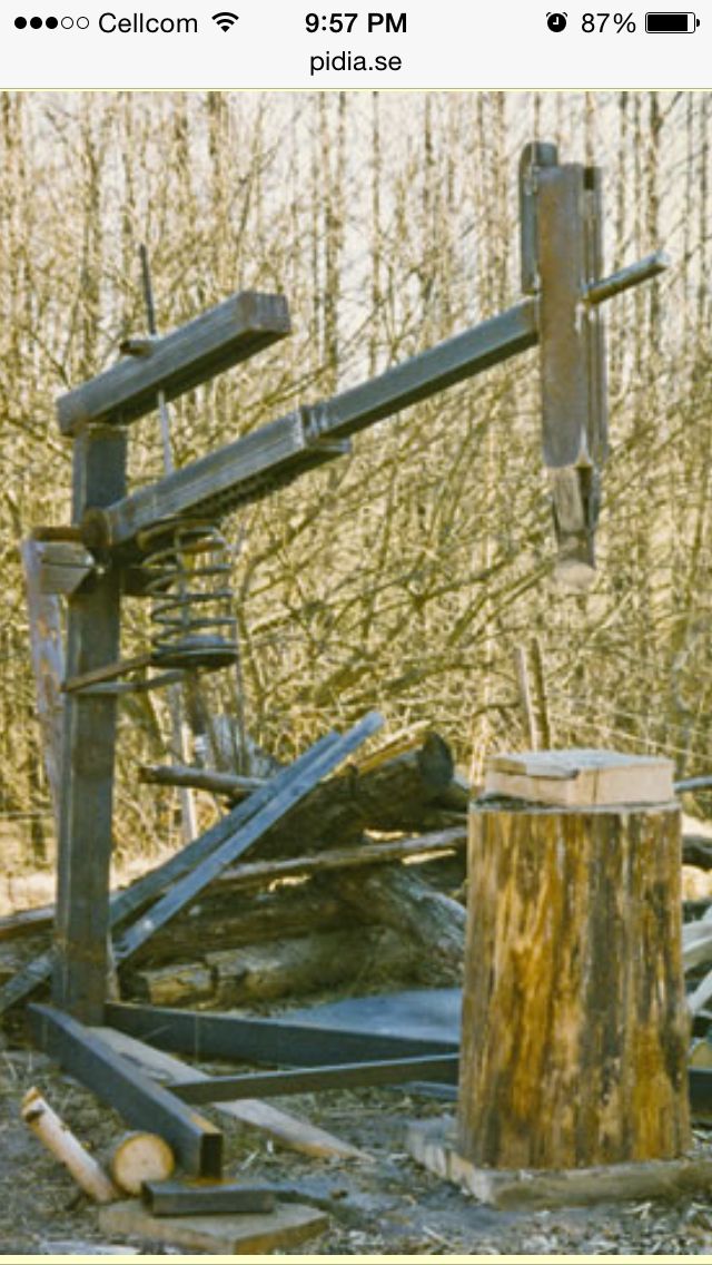 an old broken down tree in the woods next to a pile of wood and logs