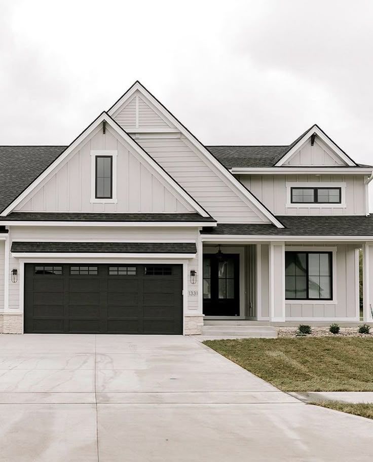 a large white house with black garage doors