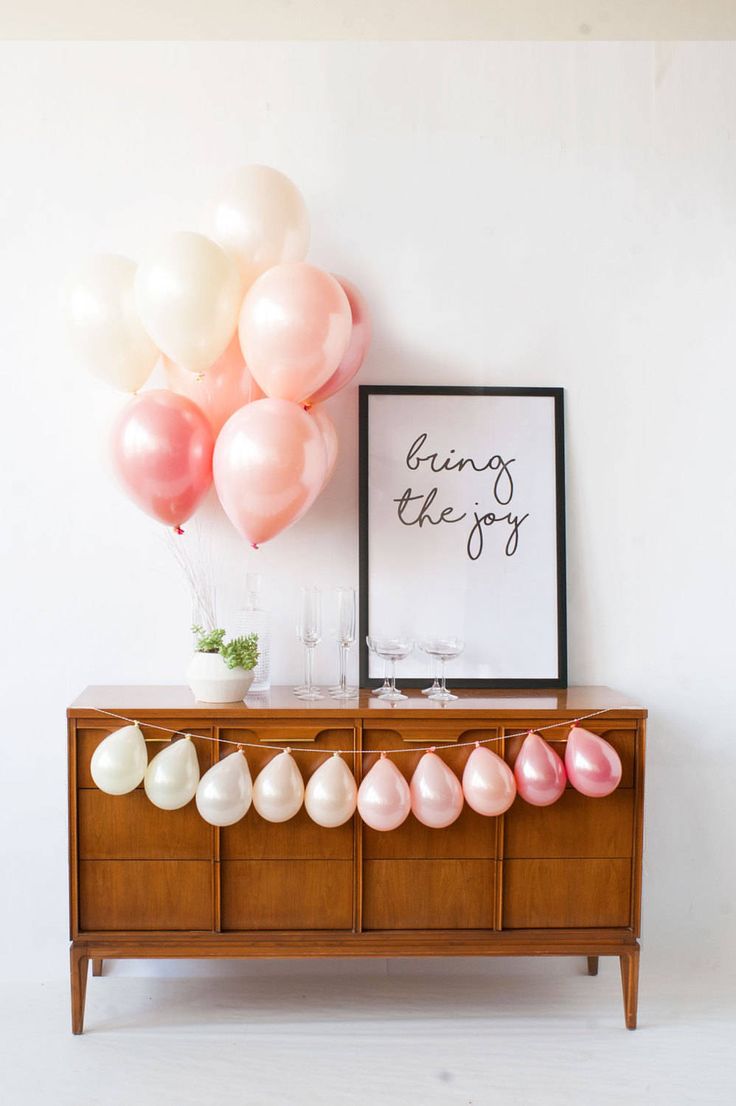 balloons are hanging on the wall next to a dresser