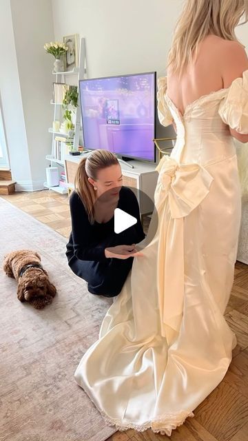 a woman in a wedding dress standing next to a dog