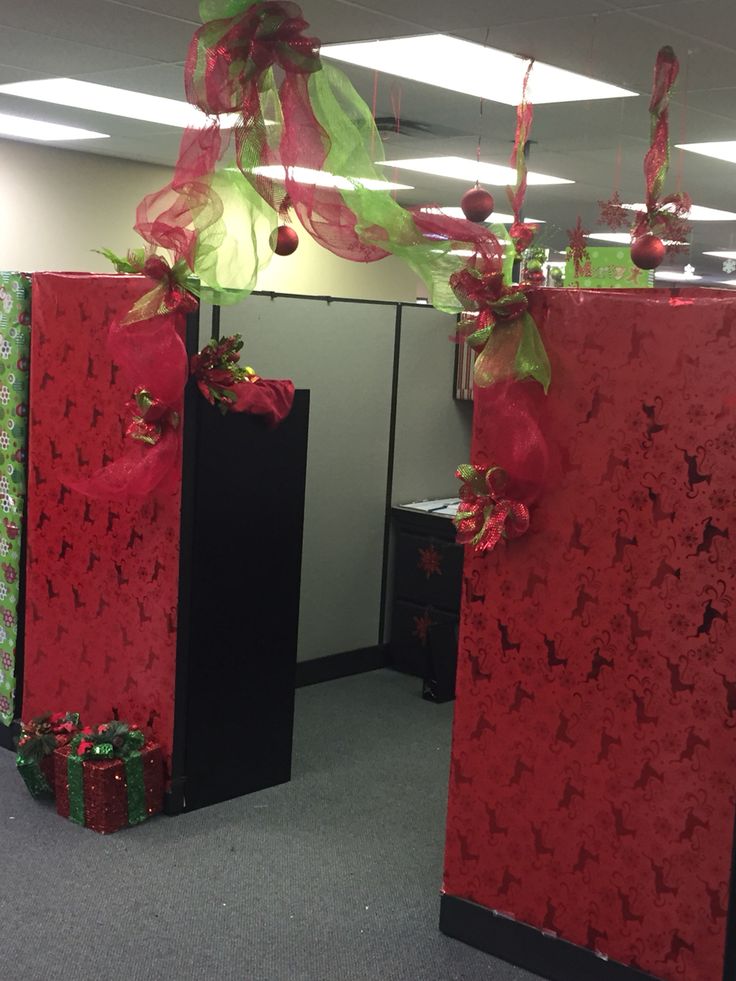 two red boxes with presents tied to them in the middle of an office cubicle