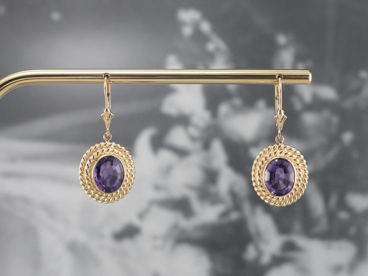 Sophisticated and yet interesting, these earrings feature bright bursts of color from the amethysts and an excellent shine from every facet. The perfect size to transition from day to evening, these lovely earrings are sure to be a favorite of your jewelry wardrobe. Metal: 14K Yellow Gold Gem: 2 Amethyst Gem Measurements: 9.8 x 7.7 mm, Oval Earrings Length: 34 mm Earrings Width: 15 mm Marks: “14K” Stamped on the Findings Purple Oval Fine Jewelry Earrings, Oval Amethyst Earrings With Gemstone Accents, Purple Oval Earrings With Gemstone Accents, Formal Amethyst Drop Earrings, Elegant Oval Amethyst Earrings, Formal Oval Faceted Earrings, Purple Faceted Earrings For Anniversary, Jewelry Wardrobe, Oval Earrings