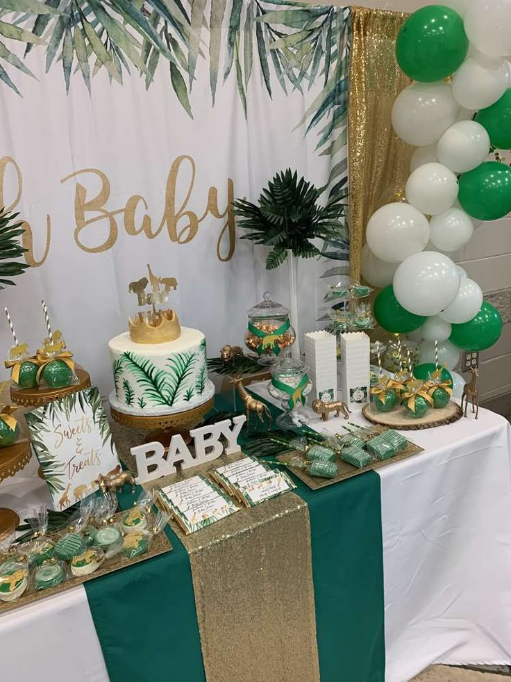 a table topped with lots of green and white desserts next to a palm tree