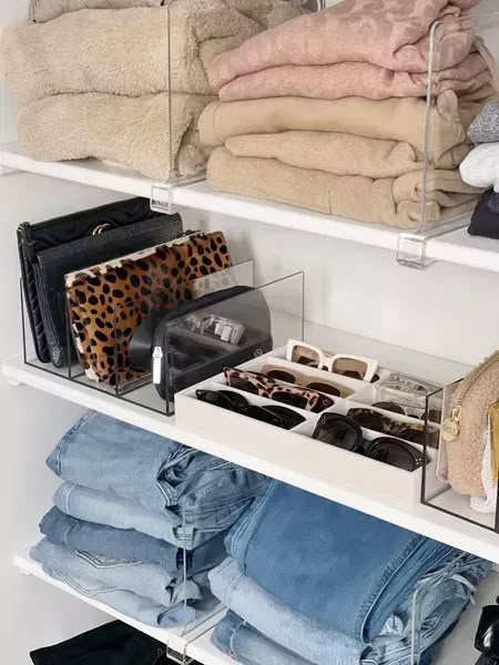 an organized closet with jeans, shoes and handbags on shelves in white shelving