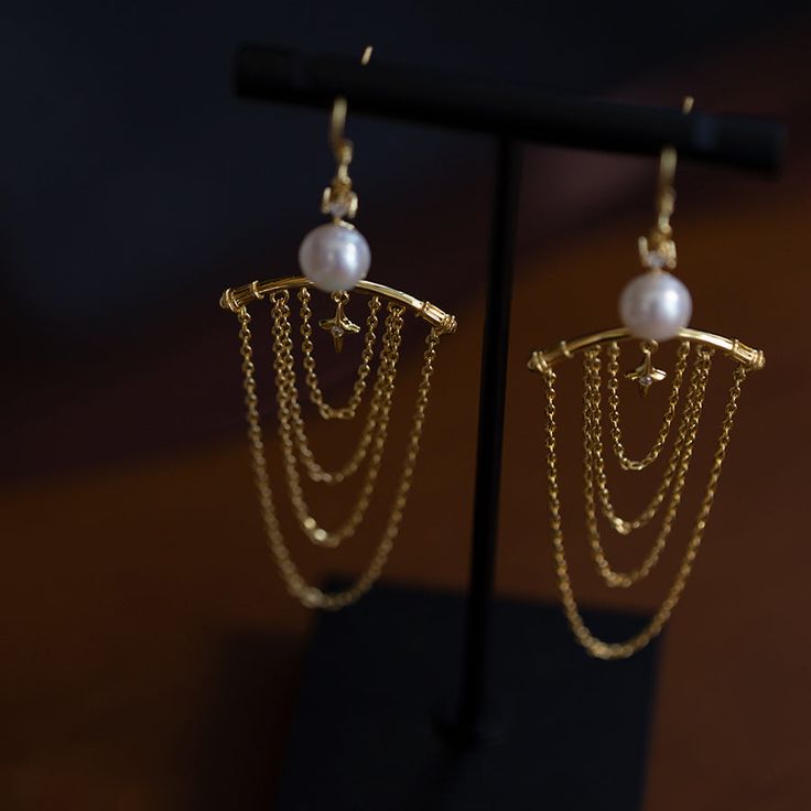 Earrings inspired by the decorative capitals of ancient Greek temple architecture. An item with a series of hanging golden chains that look like tassels. The lustrous pearls give off a lustrous light. A retro item with an exotic scent. 
 
 
 Type 
 
 Earrings 
 
 
 Size 
 
 Height: 8.4cm 
 Width: 2.7cm 
 
 
 Material 
 
 Silver925 
 Alloy 
 Natural pearl 
 
 
 Others 
 
 If you have a metal allergy or the plating does not suit your skin, please refrain from ordering. String Earrings, Greek Temple, Temple Architecture, Ancient Greek, Natural Pearls, Metallica, Lego, Plating, Architecture