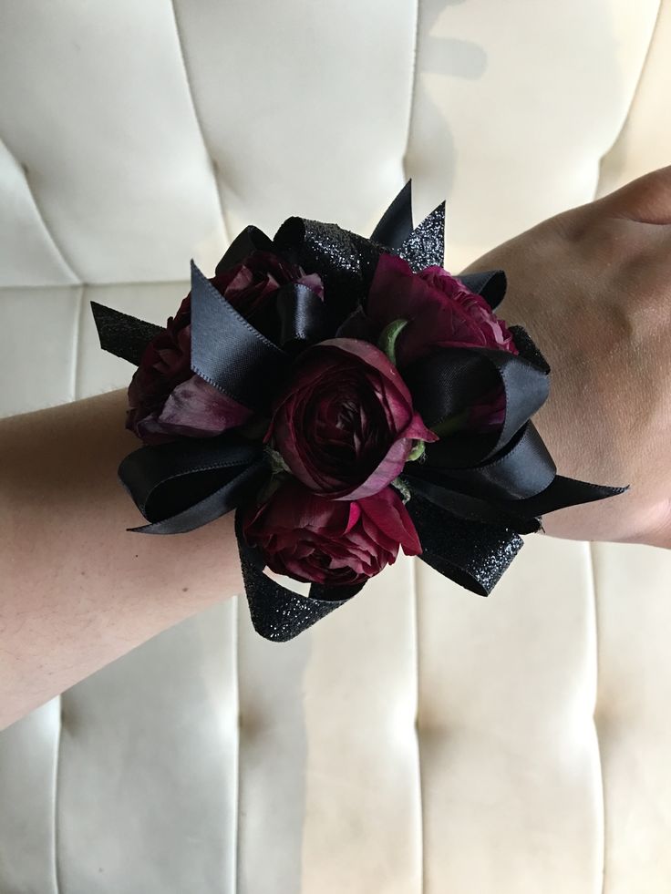 a close up of a person's arm wearing a flower wrist corsage