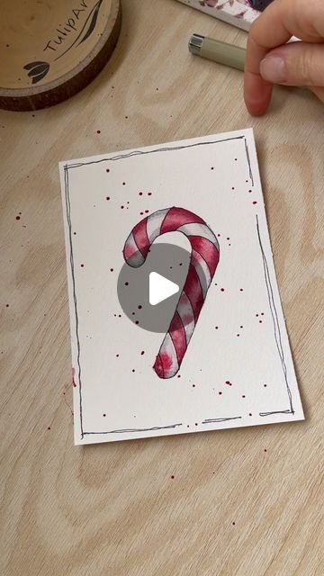 someone is drawing a candy cane on paper