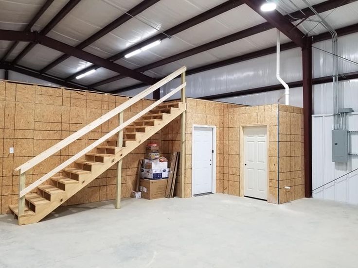 the inside of a building that is being built with wooden walls and stairs in it