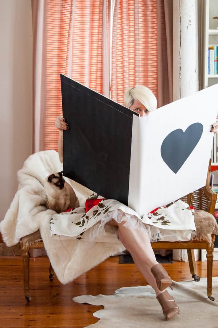 a woman sitting on a chair with a laptop in front of her and a heart drawn on the screen