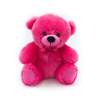 a pink teddy bear sitting on top of a white surface