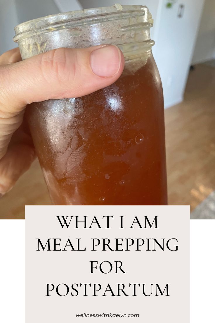 a hand holding a mason jar filled with liquid and the words what i am meal prepping for postpartum