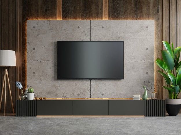 a tv mounted on the wall in a living room with potted plants next to it