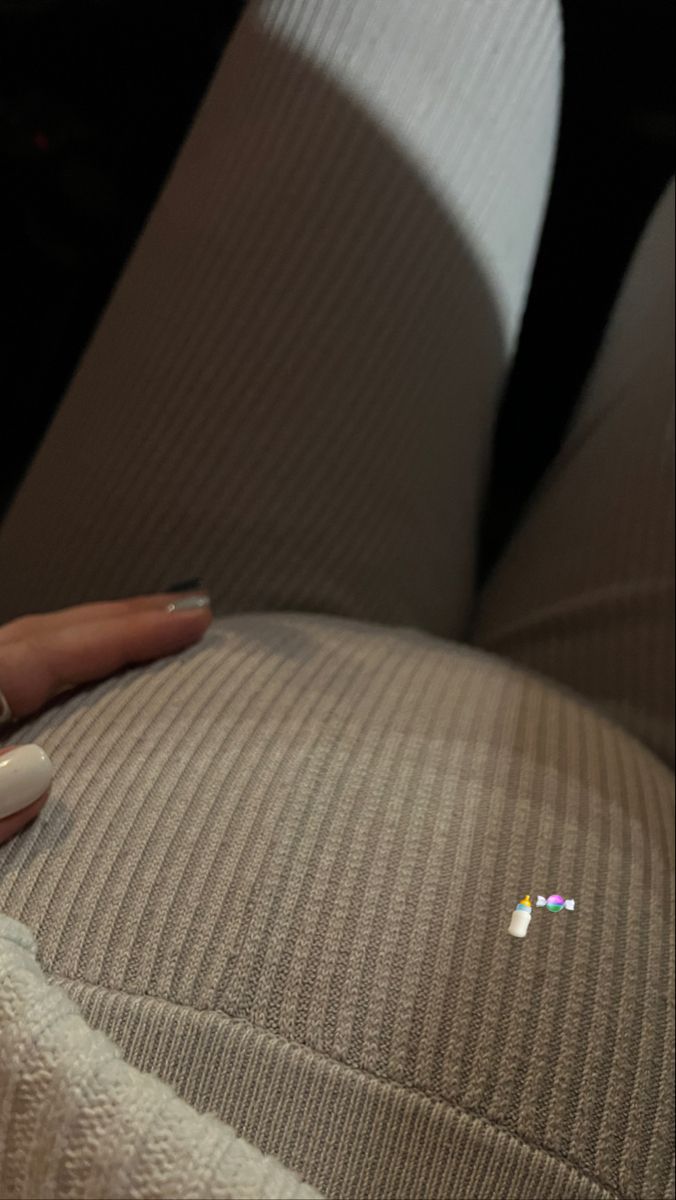 a woman's hand on the back of a car seat with a remote control