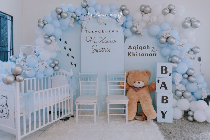 a teddy bear sitting in front of a baby's room with balloons and decorations