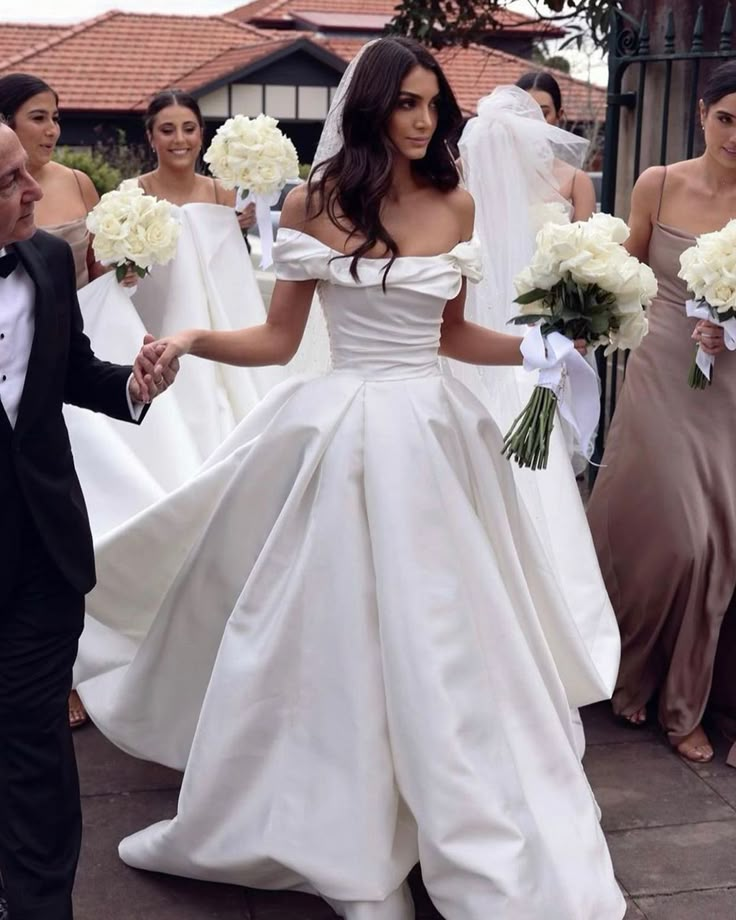 the bride and groom are walking down the street with their bridal party in the background