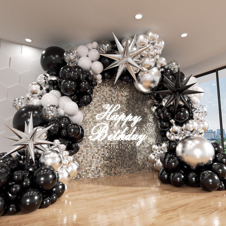 black and white balloons are arranged in the shape of an arch with stars, snowflakes, and happy birthday written on it