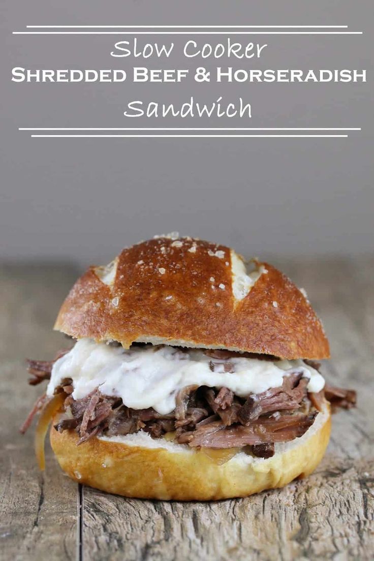 slow cooker shredded beef and horseradish sandwich on a wooden table with text overlay