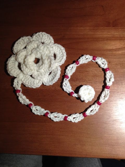 a crocheted flower and headband sitting on top of a wooden table