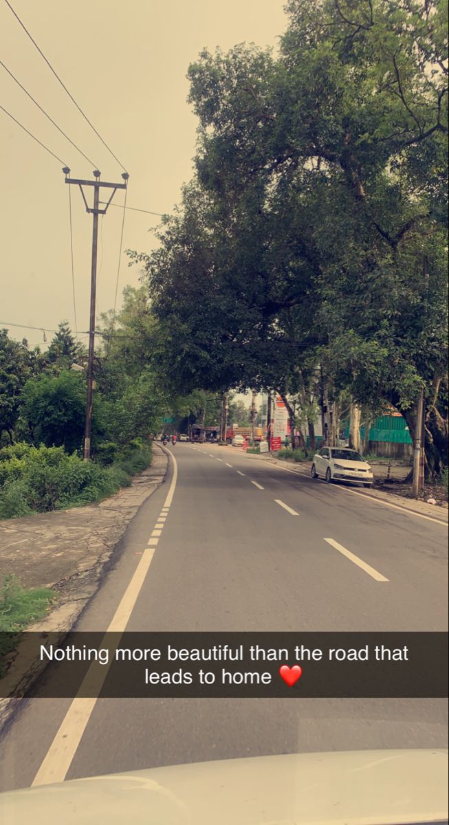 a car driving down a street next to trees