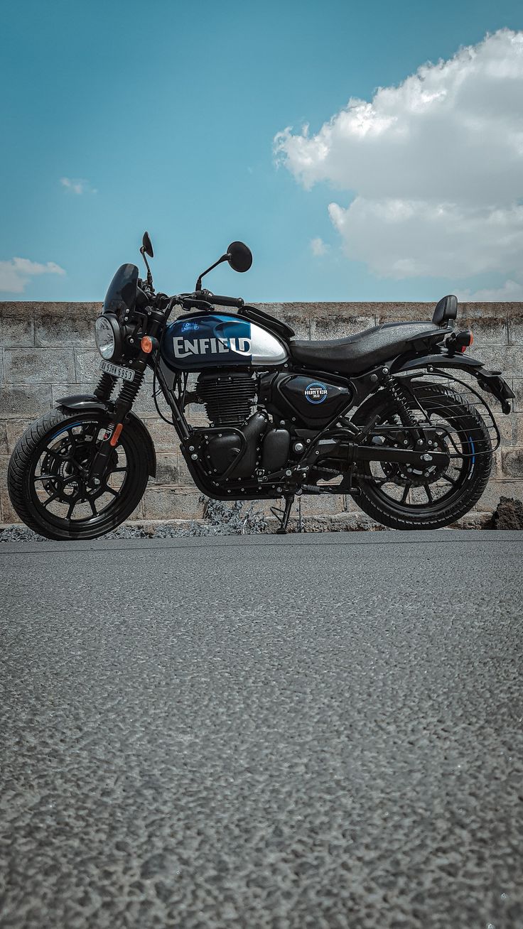 a police motorcycle is parked on the side of the road in front of a stone wall