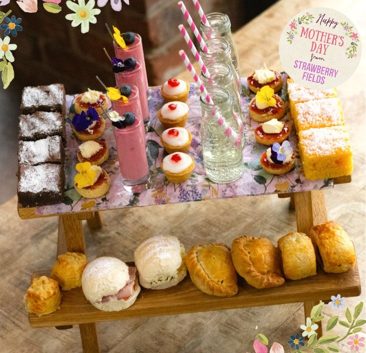 an assortment of pastries and desserts on a table with flowers in the background