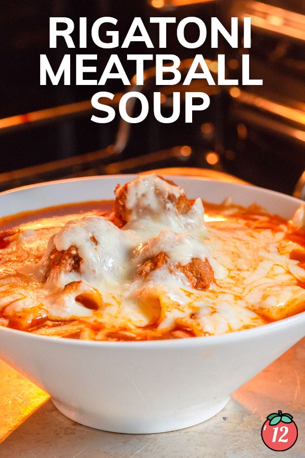 a white bowl filled with meatball soup sitting on top of a counter next to an oven