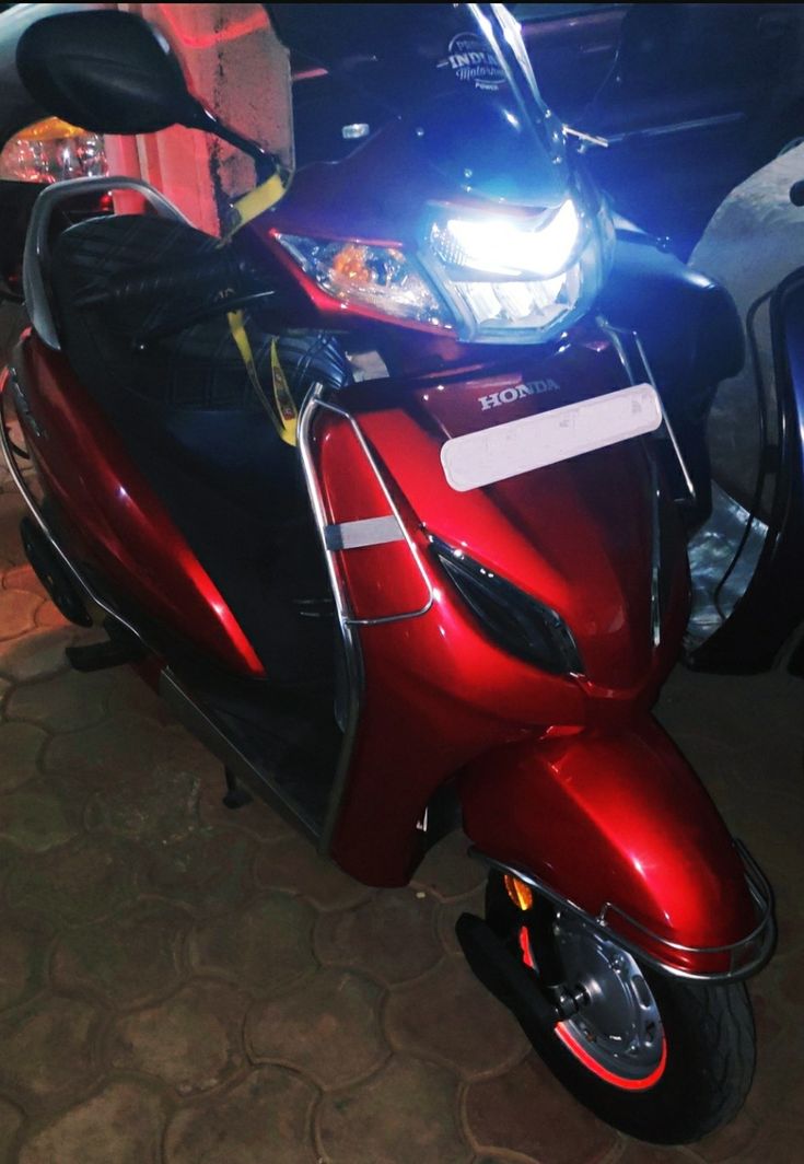 a red scooter is parked on the street