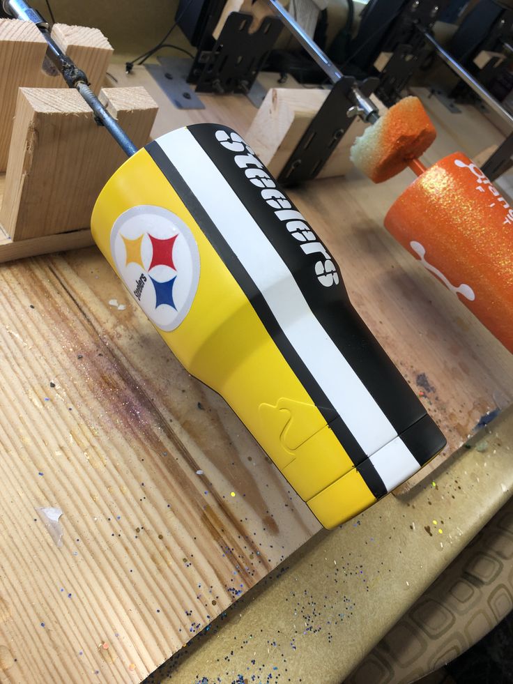 a close up of a yellow and white object on a wooden table with other tools