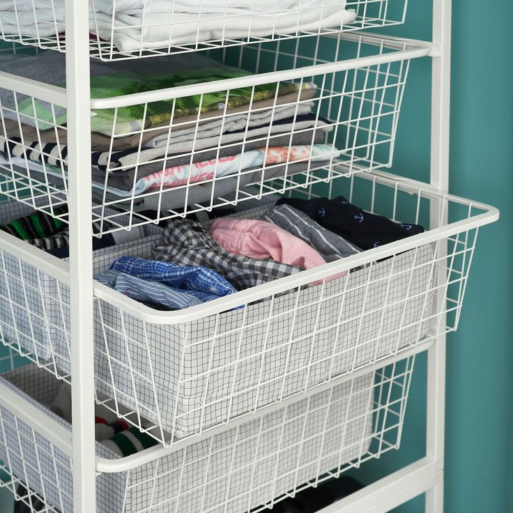 a white wire shelf filled with folded clothes