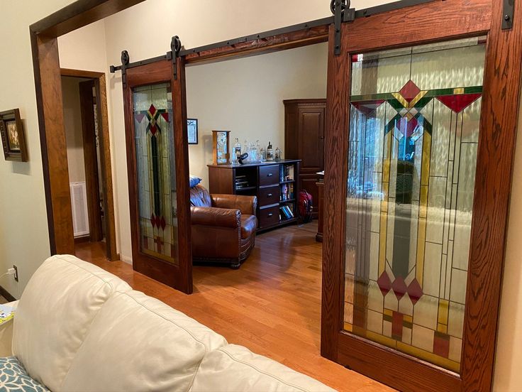 a living room filled with furniture and stained glass doors