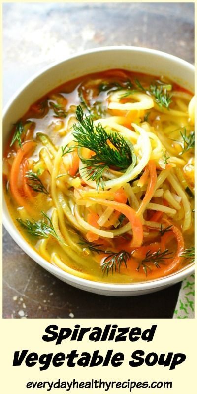 a white bowl filled with vegetable soup on top of a table