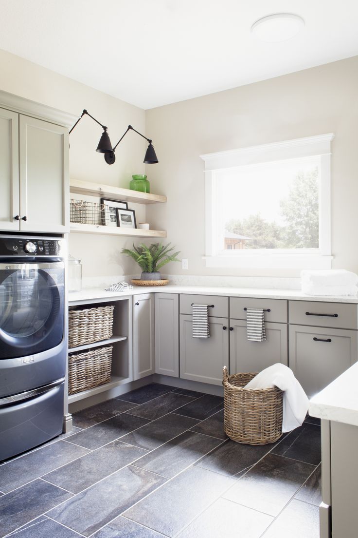 a washer and dryer sitting in a kitchen next to a window with lights on