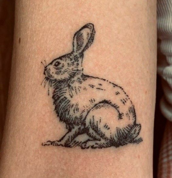 a black and white drawing of a rabbit on the arm