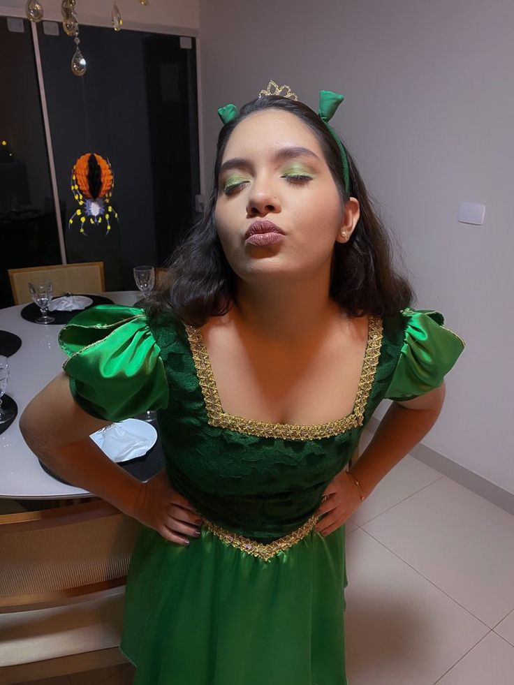 a woman in a green dress poses for the camera